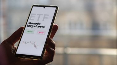 Etf fonunu analiz eden bir yatırımcı. İspanyolca ETF metni: uzun / kısa para birimi, satın al, sat.