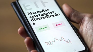 Etf fonunu analiz eden bir yatırımcı. İspanyolca ETF metni: gelişmekte olan piyasaların çeşitlendirilmesi, alınması ve satılması.
