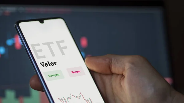 Stock image An investor analyzing an etf fund. ETF text in Spanish : value, buy, sell.