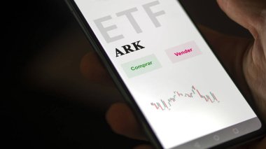 Mart 2023, etf fonunu analiz eden bir yatırımcı. İspanyolca ETF metni: ARK, satın al, sat.