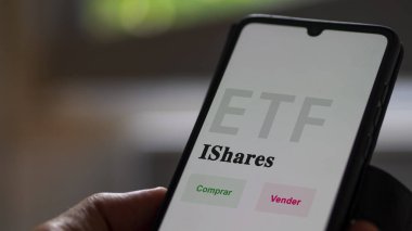 Etf fonunu analiz eden bir yatırımcı. İspanyolca ETF metni: iShares, al, sat.