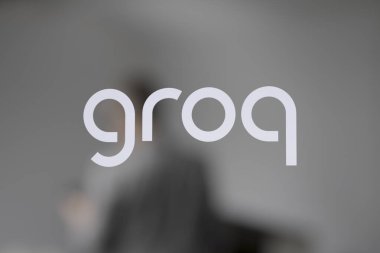 Logo Groq ofis penceresinde. Arka planda bulanık bir insan.