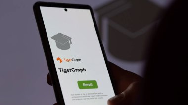 24 Mart 2024. Öğrenci telefondaki TigerGraph programına kaydoluyor, e-öğrenme yoluyla canlandırıcı sertifika