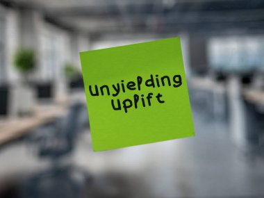 Post note on glass with 'Unyielding Uplift'. clipart