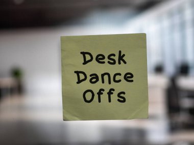 Post note on glass with 'Desk Dance Offs'. clipart