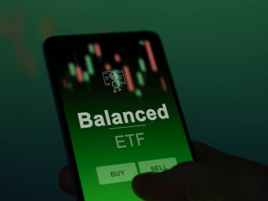 Ekrandaki dengeli etf fonunu analiz eden bir yatırımcı. Dengeli telefon fiyatlarını gösterir