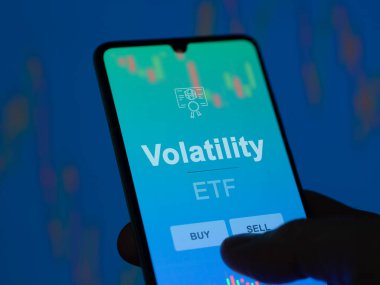 Bir yatırımcı ekrandaki dalgalanma etf fonunu analiz ediyor. Bir telefon uçuculuğun fiyatlarını gösterir