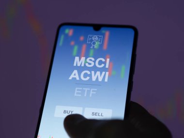 Ekrandaki Msci acwi etf fonunu analiz eden bir yatırımcı. Bir telefon MSCI ACWI fiyatlarını gösteriyor