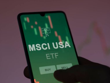 Ekrandaki Msci usa etf fonunu analiz eden bir yatırımcı. MSCI USA 'nın fiyatlarını gösteren bir telefon
