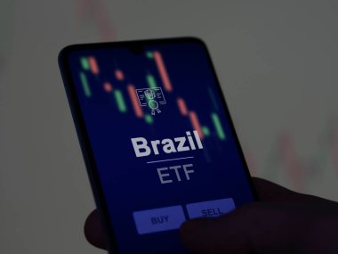 Brezilya ETF fonunu ekranda analiz eden bir yatırımcı. Brezilya 'nın fiyatlarını gösteren bir telefon