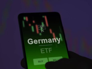 Bir yatırımcı ekranda Almanya 'nın etf fonunu analiz ediyor. Almanya 'nın fiyatlarını gösteren bir telefon