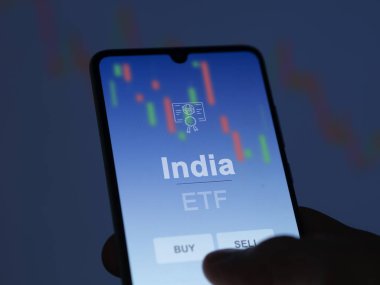 Bir yatırımcı ekranda Hindistan ETF fonunu analiz ediyor. Hindistan 'ın fiyatlarını gösteren bir telefon.