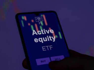 Ekrandaki aktif sermaye fonunu analiz eden bir yatırımcı. Bir telefon aktif sermaye fiyatlarını gösterir