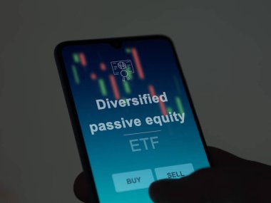 Ekranda çeşitlendirilmiş pasif sermaye etf fonunu analiz eden bir yatırımcı. Bir telefon, çeşitlendirilmiş pasif sermaye fiyatlarını gösterir