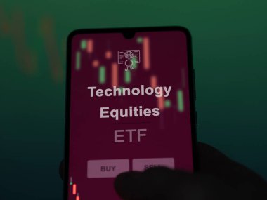 Ekrandaki teknoloji sermayesini analiz eden bir yatırımcı. Teknoloji Varlıkları 'nın fiyatlarını gösteren bir telefon