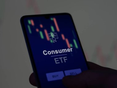 Ekranda tüketici fonunu analiz eden bir yatırımcı. Bir telefon tüketicinin fiyatlarını gösterir