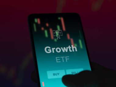 Ekrandaki büyüme fonunu analiz eden bir yatırımcı. Bir telefon büyümenin fiyatlarını gösterir