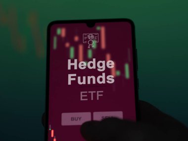 Yatırımcı, perdede yatırım fonlarını analiz ediyor. Hedge Funds 'un fiyatlarını gösteren bir telefon