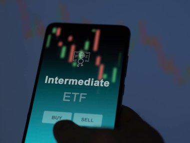 Bir yatırımcı, ekranda orta seviye etf fonunu analiz ediyor. Bir telefon orta fiyatları gösterir