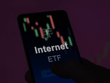 Ekranda internet fonunu analiz eden bir yatırımcı. Bir telefon internetin fiyatlarını gösterir