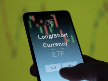 Ekrandaki uzun / kısa vadeli etf fonunu analiz eden bir yatırımcı. Uzun / Kısa Para Biriminin fiyatlarını gösteren bir telefon