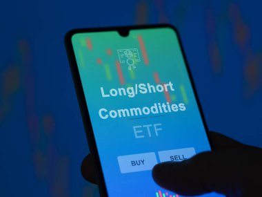 Bir yatırımcı, ekrandaki uzun-kısa metaların etf fonunu analiz ediyor. Bir telefon Uzun / Kısa ödenen malların fiyatlarını gösterir