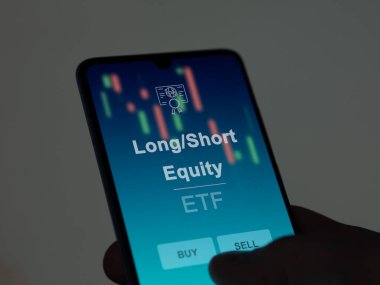 Ekrandaki uzun / kısa vadeli hisse senedini analiz eden bir yatırımcı. Uzun / Kısa Ödenek 'in fiyatlarını gösteren bir telefon