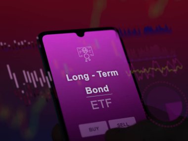 Ekrandaki uzun vadeli tahvil fonunu analiz eden bir yatırımcı. Uzun vadeli tahvillerin fiyatlarını gösteren bir telefon