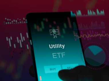 Yatırımcı, ekranda etf fonunu analiz ediyor. Bir telefon, hizmetin fiyatlarını gösterir