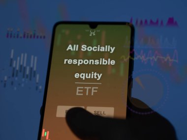 Bir yatırımcı ekrandaki tüm sosyal sorumluluk sermaye etf fonunu analiz ediyor. Bir telefon tüm sosyal sorumluluk sahiplerinin fiyatlarını gösterir
