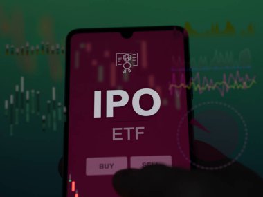 Bir yatırımcı ekrandaki ipo etf fonunu analiz ediyor. Bir telefon halka arz fiyatlarını gösterir