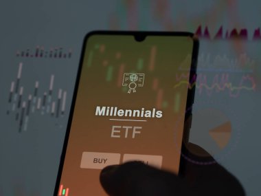 Ekranda milenyum fonunu analiz eden bir yatırımcı. Bir telefon Millennials fiyatlarını gösterir