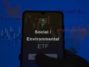 Ekranda sosyal / çevresel etf fonunu analiz eden bir yatırımcı. Sosyal / Çevresel fiyatları gösteren bir telefon