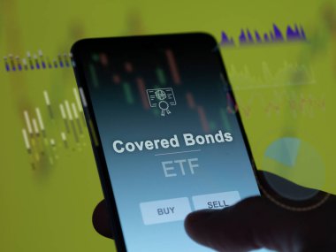 Örtülü tahvilleri analiz eden bir yatırımcı. Kapalı tahvillerin fiyatlarını gösteren bir telefon