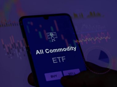 Ekrandaki tüm emtia fonlarını analiz eden bir yatırımcı. Bir telefon tüm malların fiyatlarını gösterir