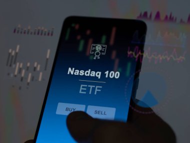 An investor analyzing the nasdaq 100 etf fund on a screen. A phone shows the prices of Nasdaq 100 clipart