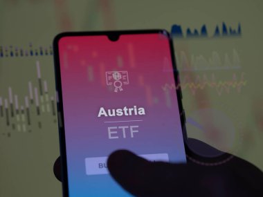 Bir yatırımcı, ekrandaki Avusturya ETF fonunu analiz ediyor. Avusturya 'nın fiyatlarını gösteren bir telefon