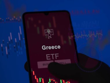 Bir yatırımcı, ekranda Yunan ETF fonunu analiz ediyor. Yunanistan 'ın fiyatlarını gösteren bir telefon