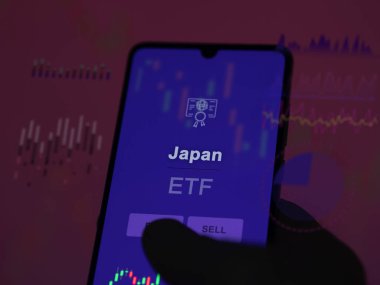 Japonya 'nın etf fonunu ekranda analiz eden bir yatırımcı. Japonya 'nın fiyatlarını gösteren bir telefon