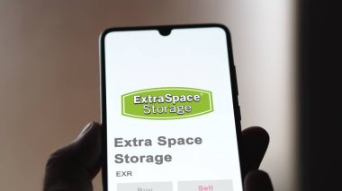 24 Nisan 2024. Ekstra Uzay Deposu 'nun logosu bir değiş tokuş ekranında. Ekstra Alan Depolama Fiyat Hisseleri, Bir aygıt üzerinde EXR $.