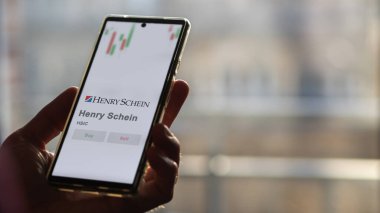 April 04th 2024. The logo of Henry Schein on the screen of an exchange. Henry Schein price stocks, $HSIC on a device. clipart