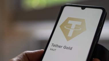 17 Nisan 2024, Şangay, Çin. Bir değiş tokuş ekranındaki (XAUT) Altın Asansörü 'nün logosuna yaklaş. (XAUT) Altın fiyatlı hisse senetleri, bir cihaza XAUT $.