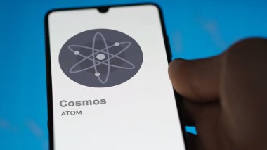 17 Nisan 2024, Şangay, Çin. Takas ekranındaki (ATOM) kozmosun logosuna yaklaş. (ATOM) Kozmos fiyat hisseleri, bir cihaz üzerinde $Atom.