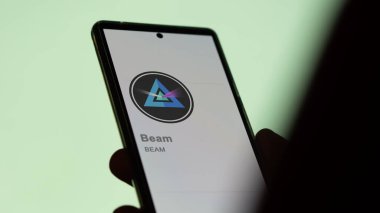 17 Nisan 2024, Şangay, Çin. Bir değiş tokuş ekranındaki (Işın) logosuna yaklaş. Fiyat hisselerini ışınla, cihaza $Beam.