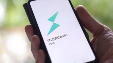 17 Nisan 2024, Şangay, Çin. Değiş tokuş ekranındaki THORChain logosunu kapat. THORChain hisse senetleri, bir cihaza harcanan para..