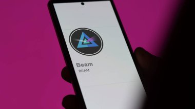 20 Nisan 2024, Şangay, Çin. Bir değiş tokuş ekranındaki (Işın) logosuna yaklaş. Fiyat hisselerini ışınla, cihaza $Beam.