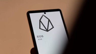 20 Nisan 2024, Şangay, Çin. Değişim ekranındaki EOS logosuna (EOS) yaklaş. (EOS) EOS fiyat hisseleri, bir aygıt üzerinde $EOS.