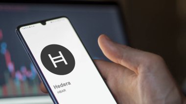 20 Nisan 2024, Şangay, Çin. Hedera 'nın logosuna bir değiş tokuş ekranında yaklaş. Hedera hisse senedi, cihaz başına $HBAR.