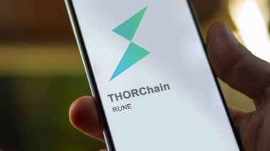 20 Nisan 2024, Şangay, Çin. Değiş tokuş ekranındaki THORChain logosunu kapat. THORChain hisse senetleri, bir cihaza harcanan para..