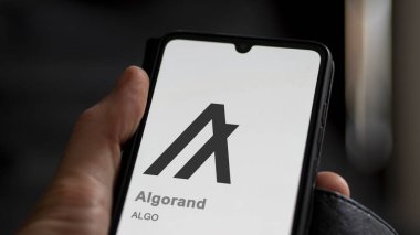 Bir değiş tokuş ekranındaki algoritmanın logosuna yaklaş. (ALGO) Algorand fiyat hisseleri, bir aygıt üzerinde $ALGO.